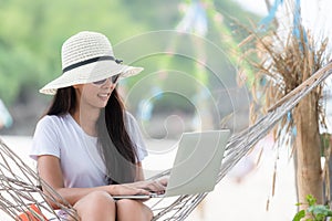 Lifestyle freelance woman using laptop working and relax on the beach.Â 